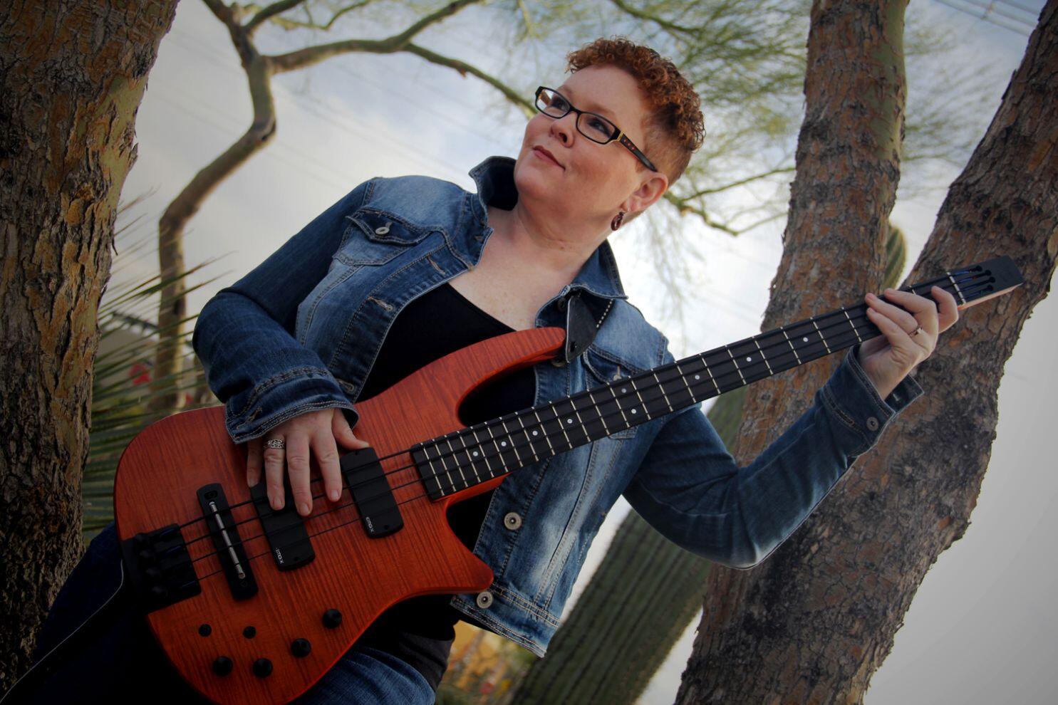 Photograph of NS Design Artist Carolyn Routh with her CR4 RADIUS Bass Guitar in Nu-Blu.