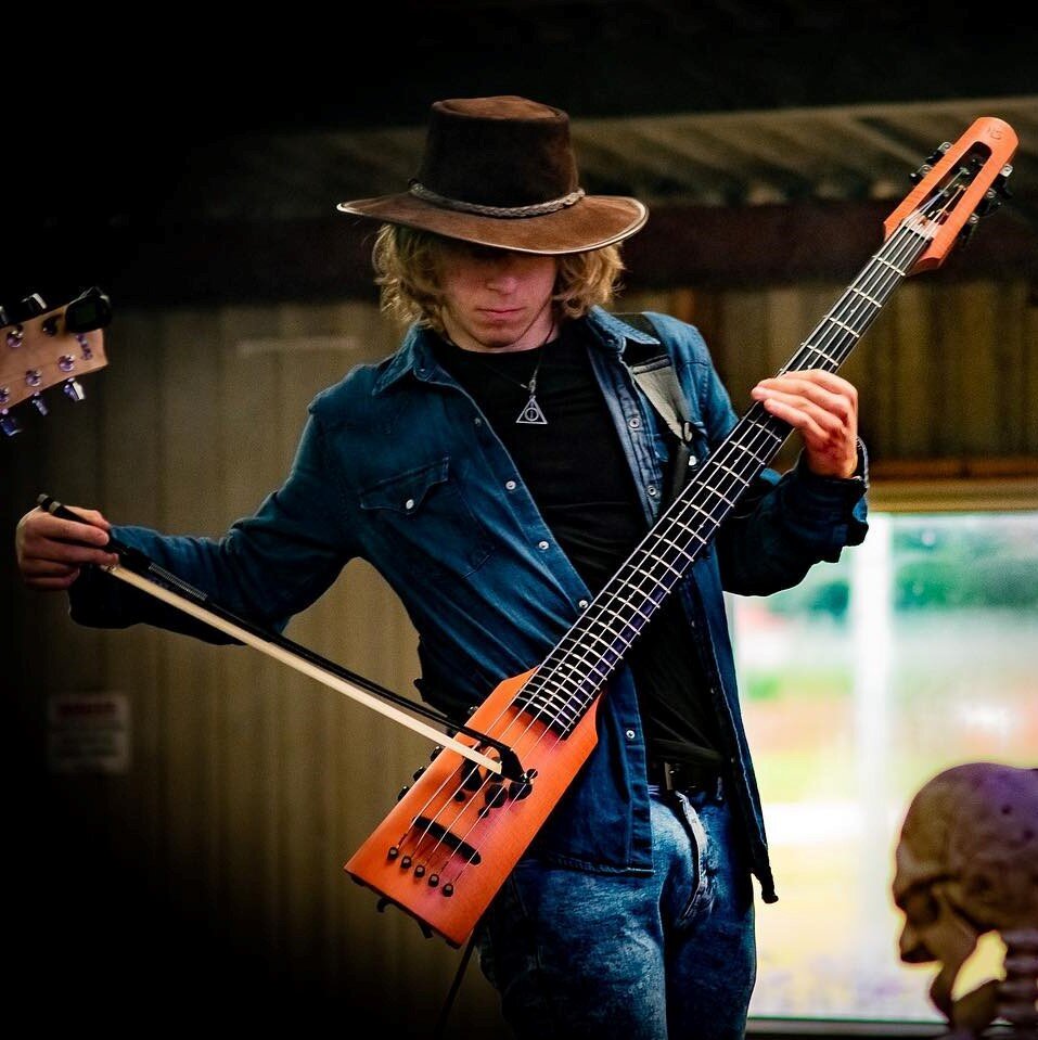 Photograph of NS Design Artist George Price playing his CR5F Omni Bass.