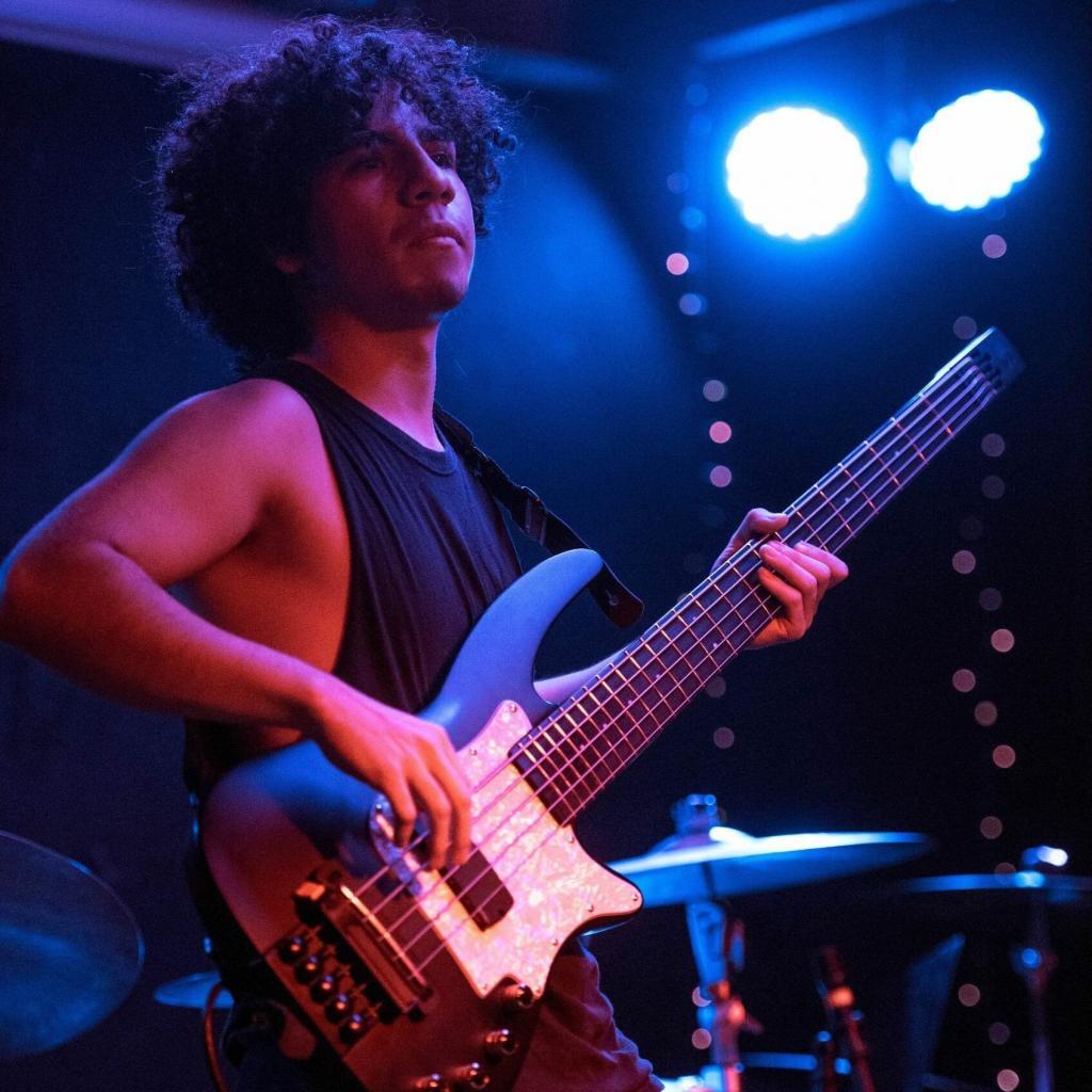 Photograph of Nick Cañas playing his customized WAV5 RADIUS Bass Guitar.