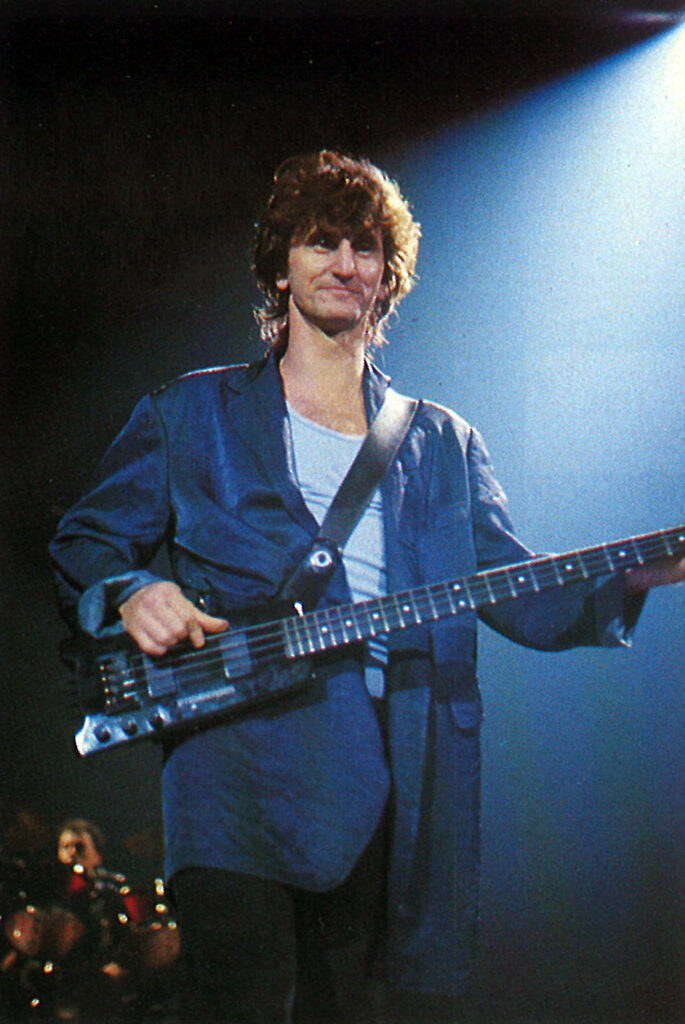 Nothing says ‘Eighties’ more than Rush’s Geddy Lee with an oversized suit jacket and an L2.
